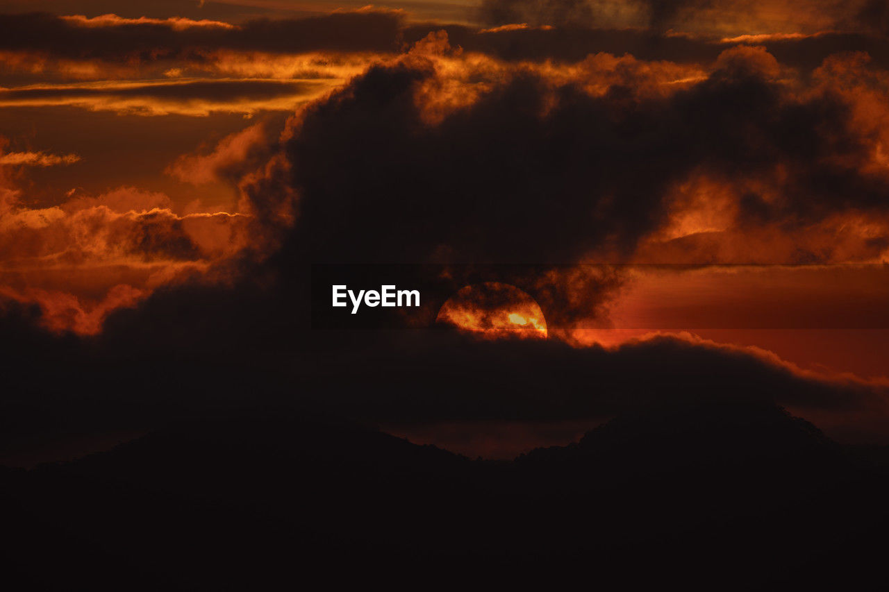 sunset, beauty in nature, cloud, sky, environment, nature, dawn, no people, mountain, afterglow, warning sign, land, heat, geology, orange color, scenics - nature, power in nature, burning, landscape, night, outdoors, lava, sign, volcano, red sky at morning, horizon, fire, erupting, smoke, evening, communication, non-urban scene