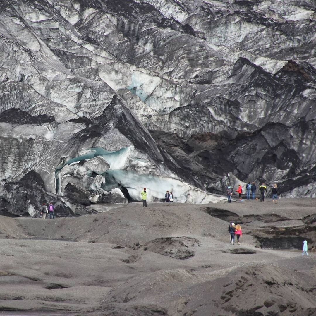 GROUP OF PEOPLE ON ROCK BY MOUNTAIN