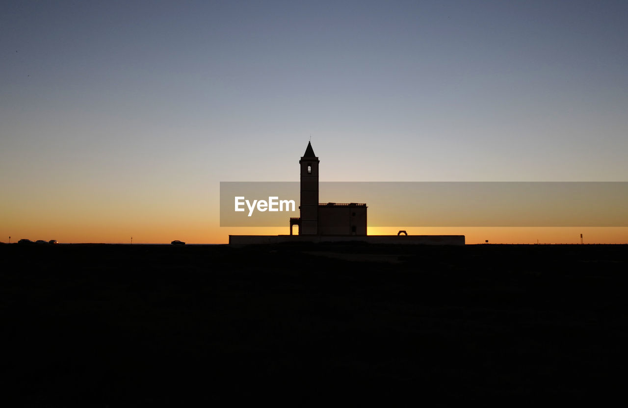 SILHOUETTE OF BUILDING AGAINST SKY AT SUNSET