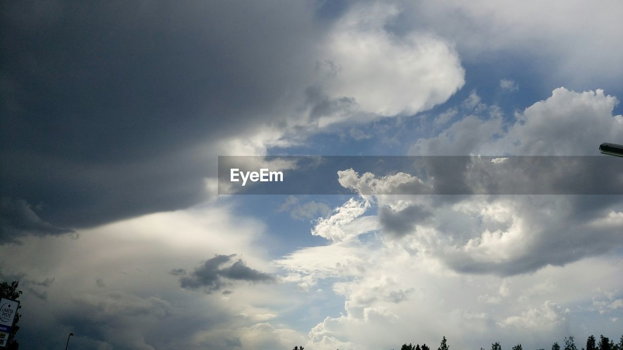 LOW ANGLE VIEW OF SUN SHINING THROUGH CLOUDS