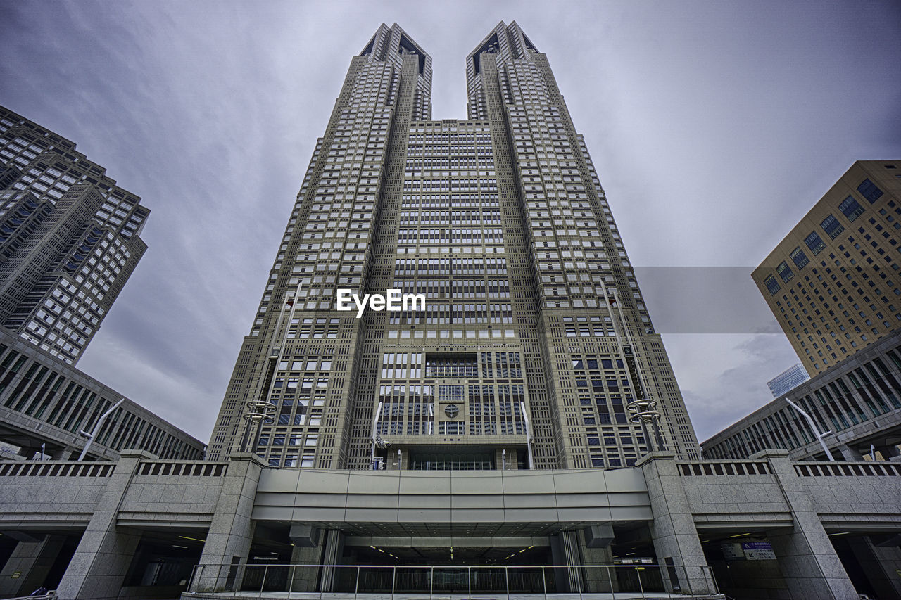 Low angle view of tokyo metropolitan government building in city against sky