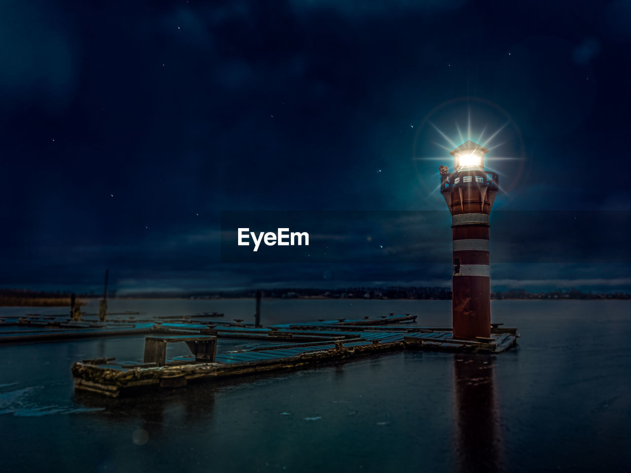 Illuminated ship moored at harbor against sky at night