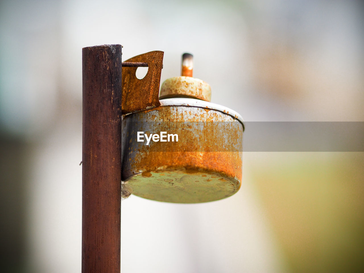 CLOSE-UP OF RUSTY METAL ON POLE