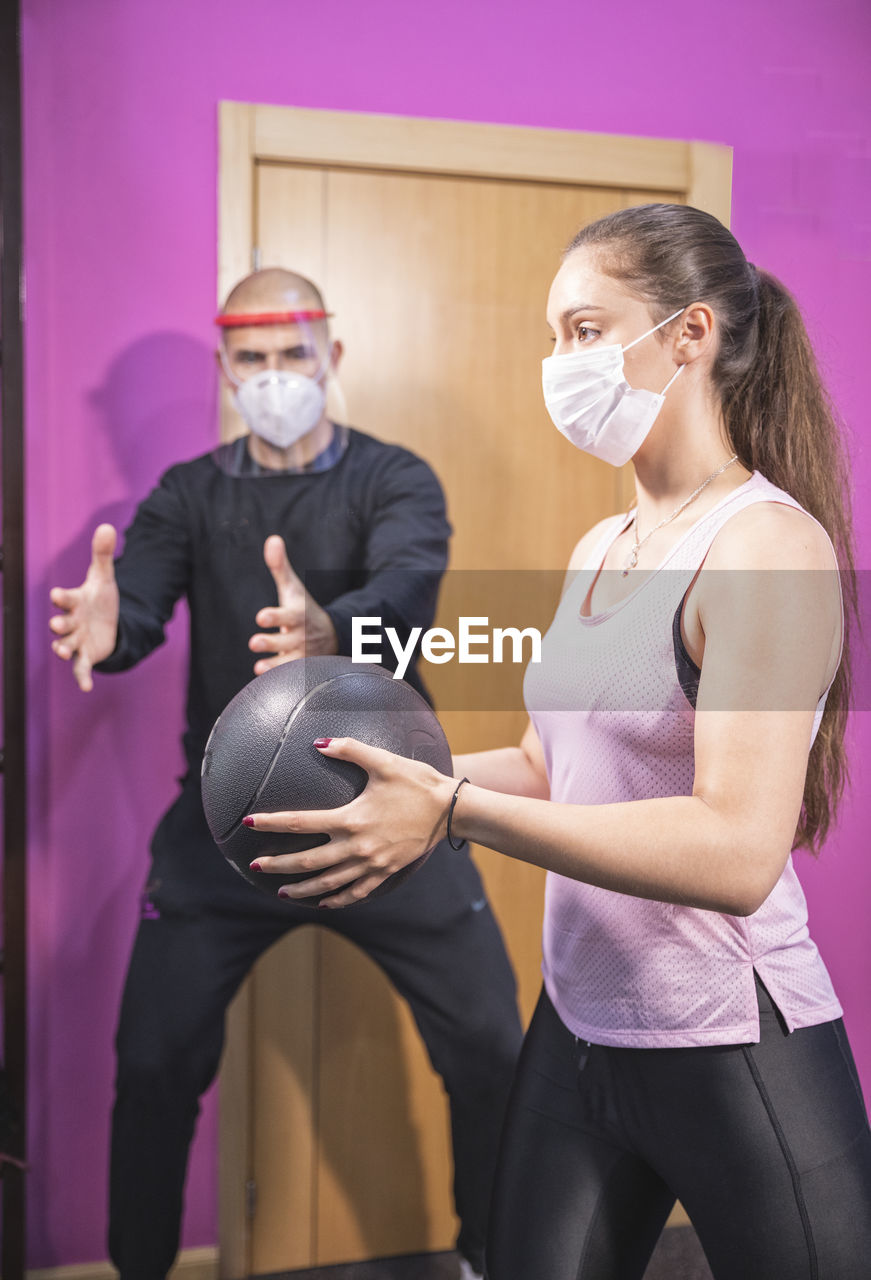 Training with personal trainer and covid19 virus protection masks