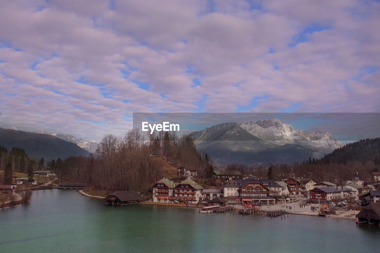 PANORAMIC VIEW OF TOWNSCAPE BY RIVER AGAINST SKY