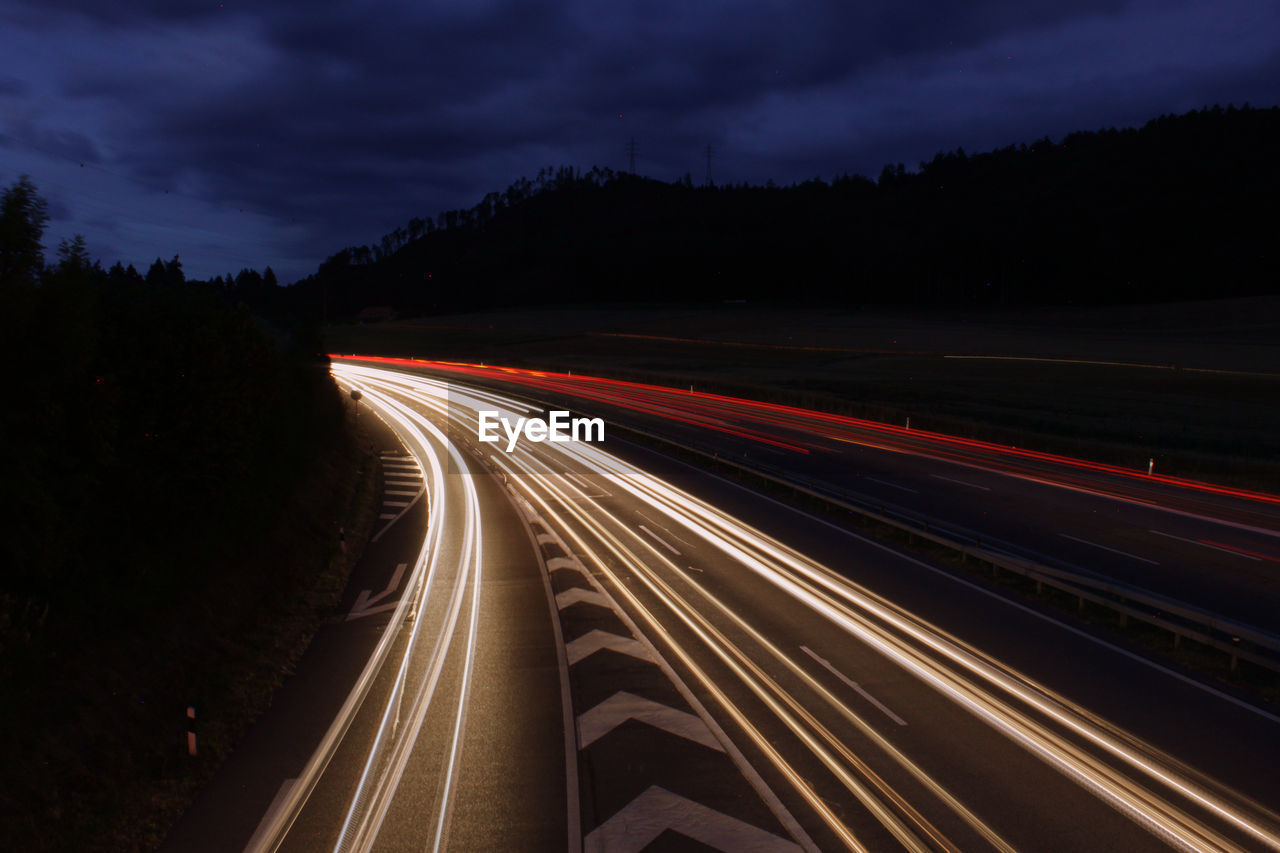 High angle view of light trails on highway at night