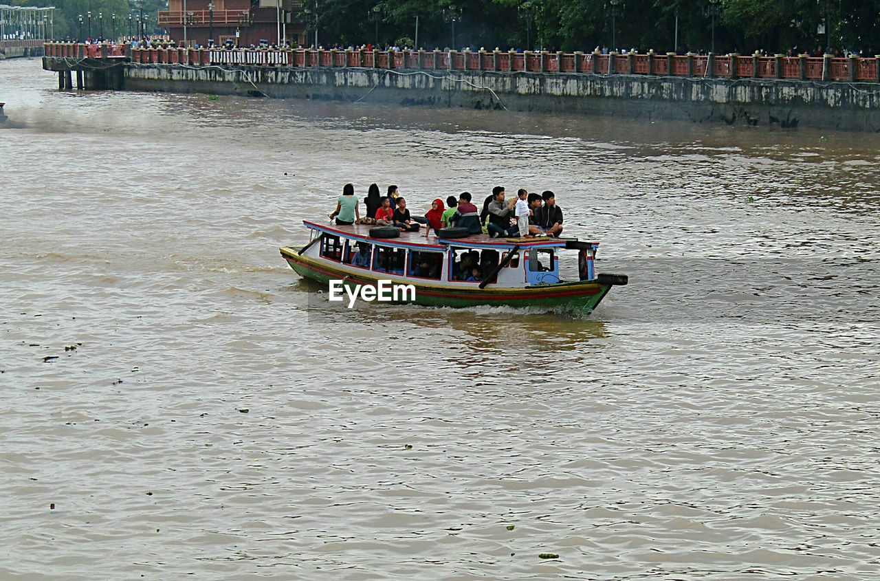 PEOPLE ROWING BOAT ON RIVER
