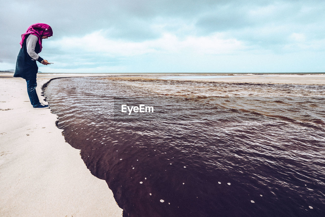 Woman photographing sea