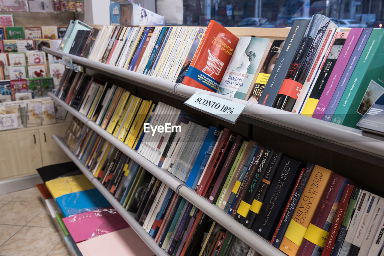 CLOSE-UP OF MULTI COLORED BOOKS IN SHELF