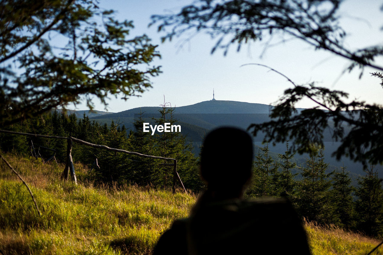 REAR VIEW OF MAN LOOKING AT VIEW