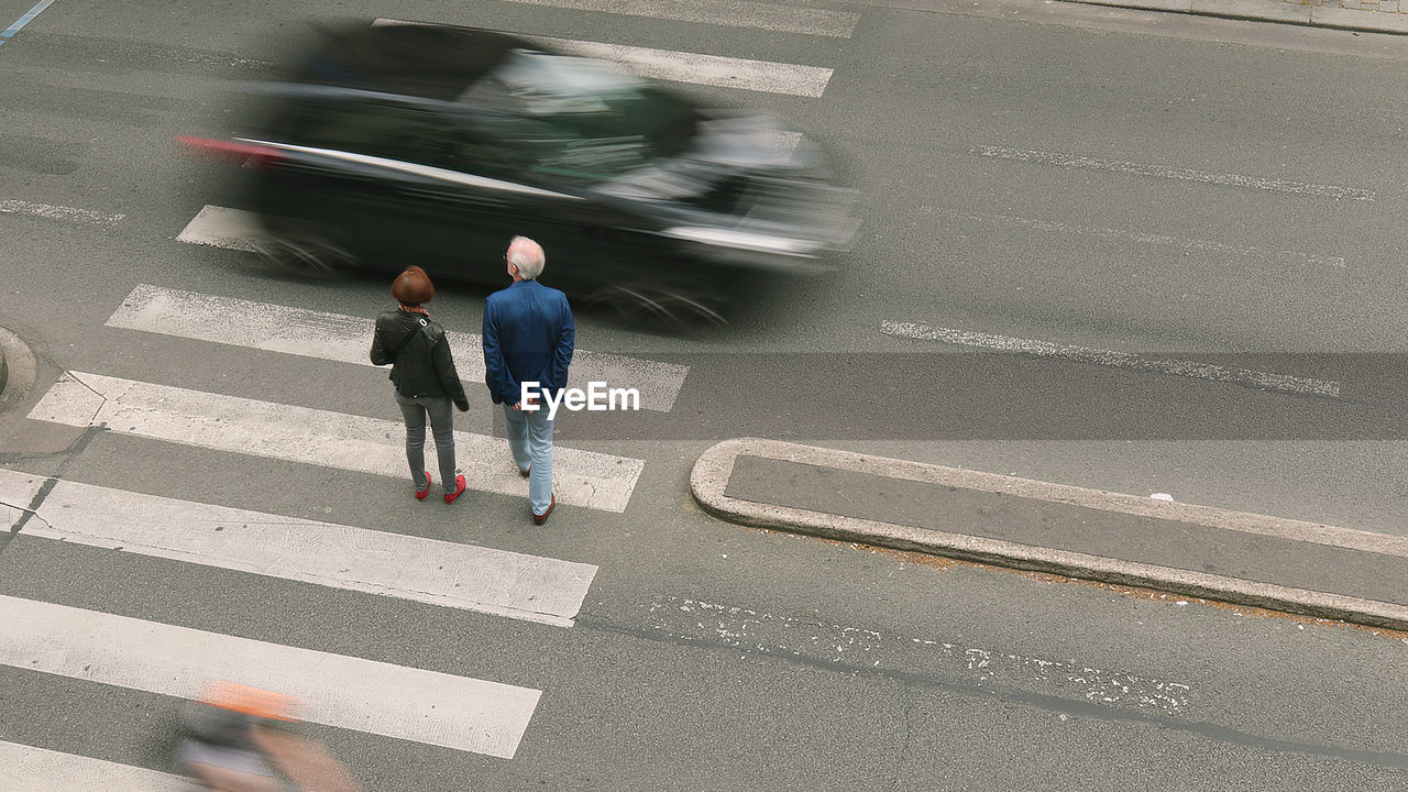 HIGH ANGLE VIEW OF COUPLE WALKING ON ROAD