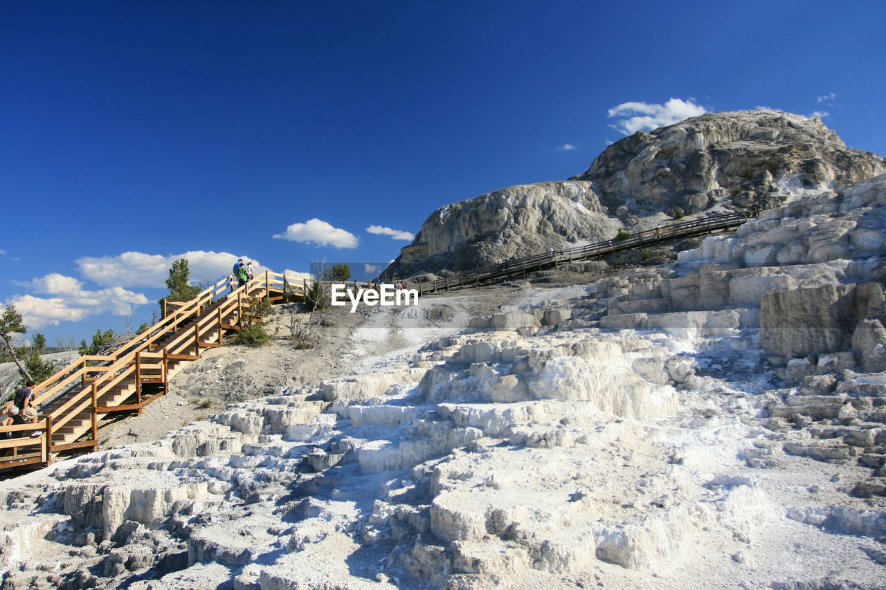 Tourist walking on boardwalk at upper terrace mammoth hot springs in yellowstone national park