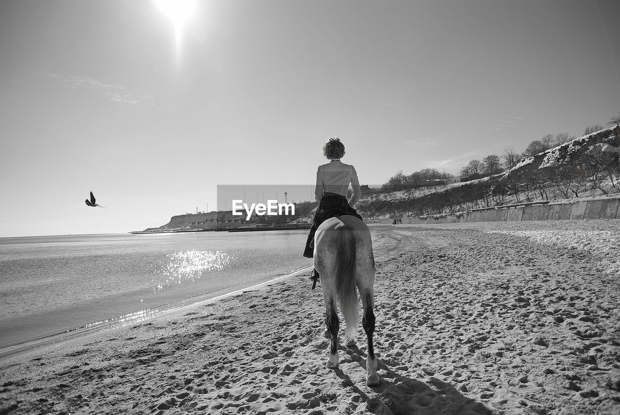 MAN ON SHORE AGAINST SKY