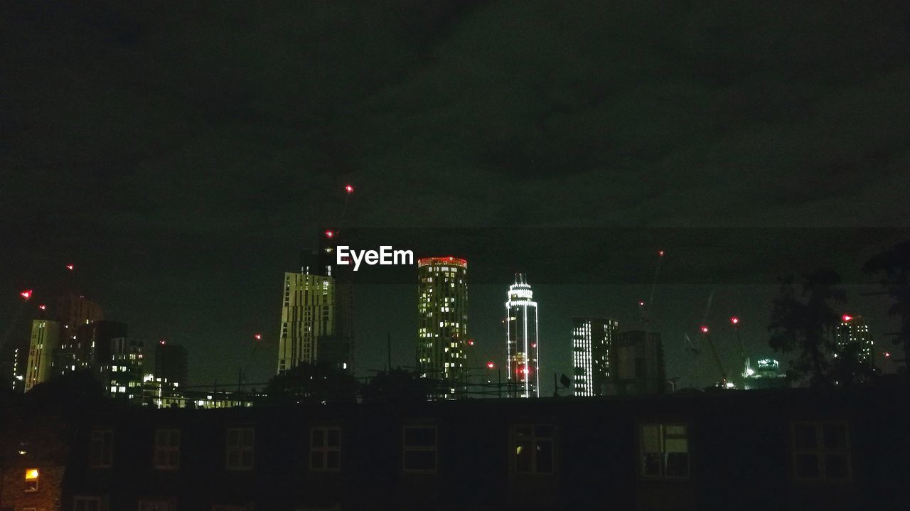 ILLUMINATED CITYSCAPE AGAINST SKY AT NIGHT