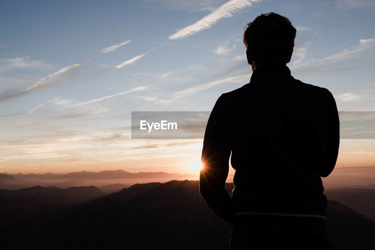 Silhouette man standing against sky during sunset