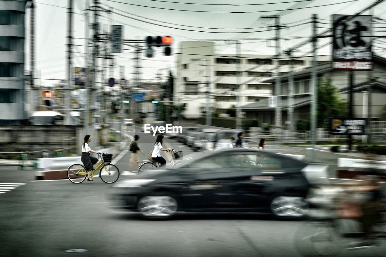 VIEW OF PEOPLE RIDING MOTORCYCLE ON ROAD