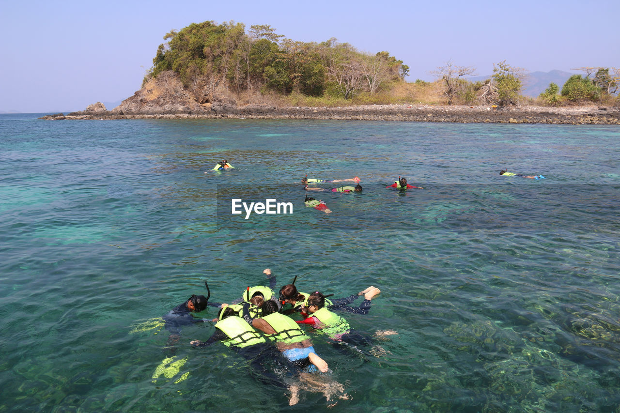 PEOPLE SWIMMING IN SEA