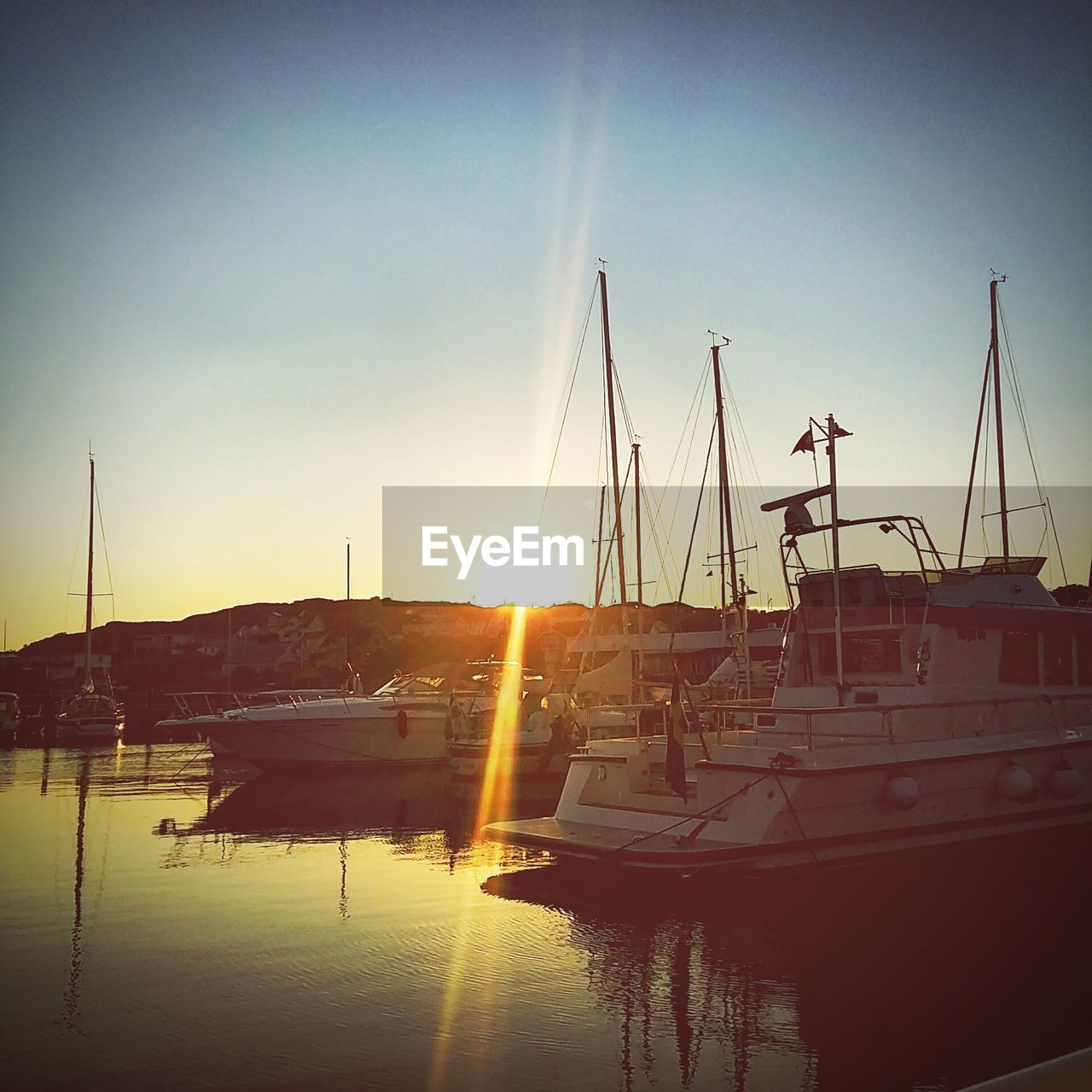 SAILBOATS IN SEA AT SUNSET