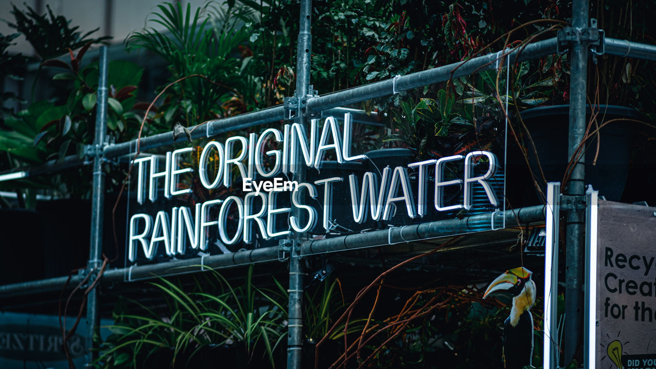 LOW ANGLE VIEW OF INFORMATION SIGN AGAINST PLANTS