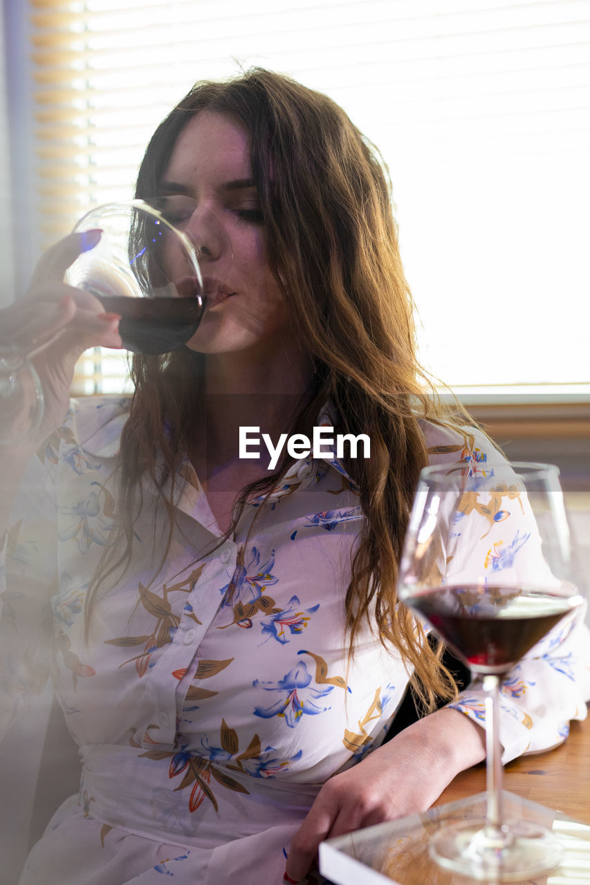 MID ADULT WOMAN DRINKING GLASS WITH BEER