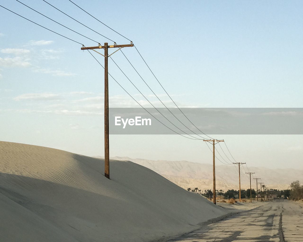 Sand dunes and power lines along a desert road