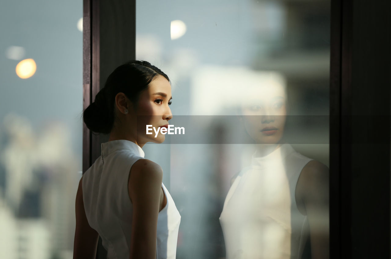 Businesswoman looking away standing by window