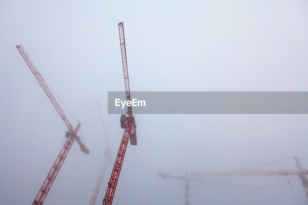 Construction with cranes in the foggy morning