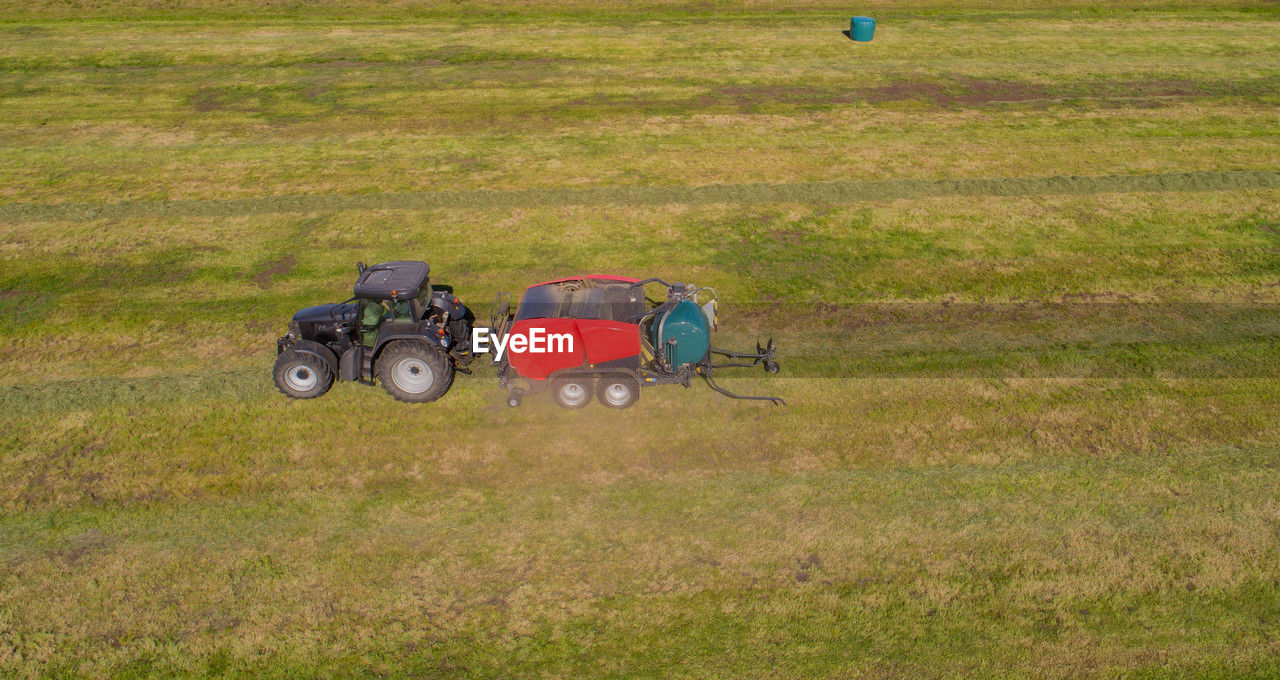 grassland, grass, field, transportation, plant, mode of transportation, land, nature, land vehicle, vehicle, day, plain, lawn, agriculture, meadow, pasture, landscape, green, prairie, environment, farm, tractor, outdoors, rural area, sports, no people, agricultural machinery, leisure activity, agricultural equipment, high angle view, growth