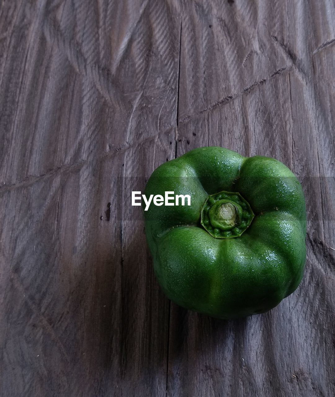green, food and drink, food, healthy eating, wellbeing, freshness, vegetable, plant, bell pepper, produce, wood, no people, indoors, still life, fruit, close-up, table, studio shot, high angle view, flower, organic, bell peppers and chili peppers, directly above, pepper, capsicum