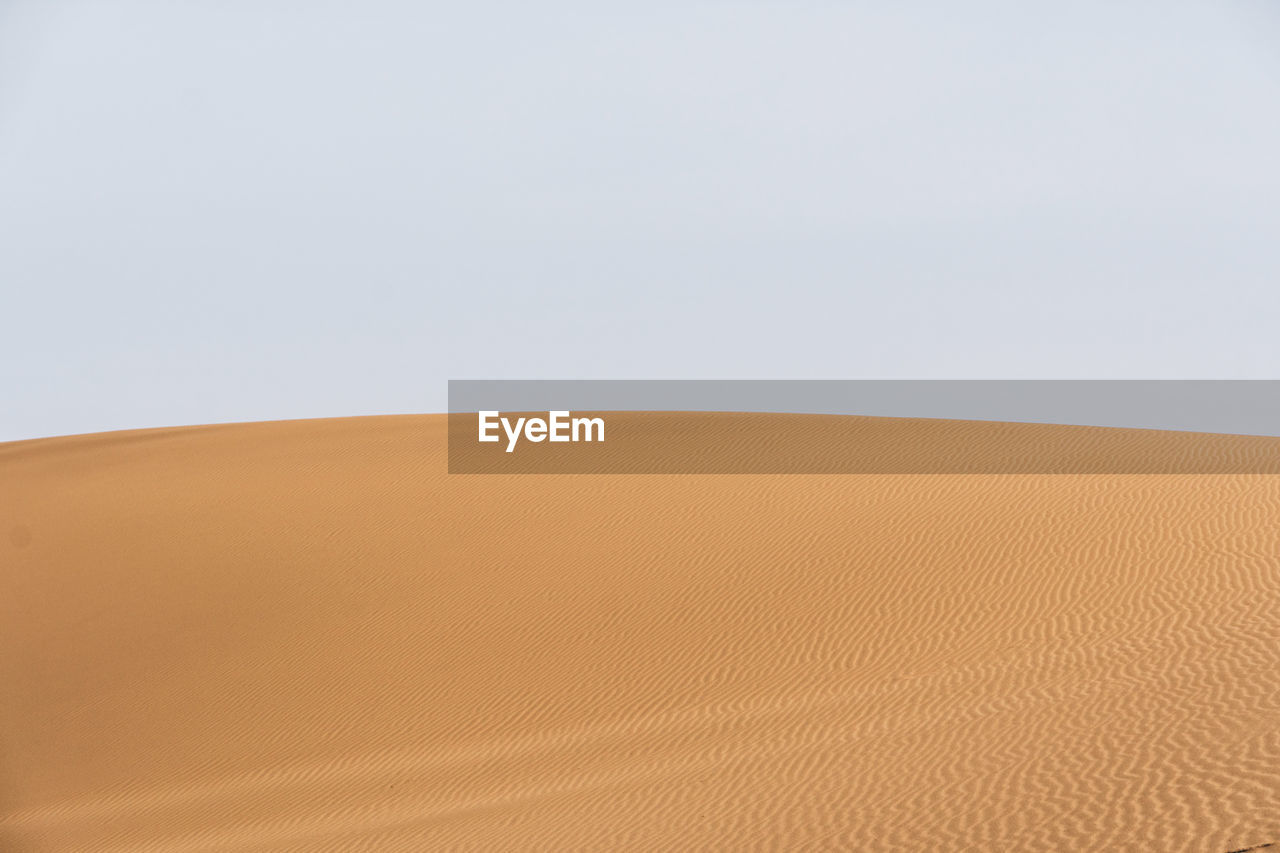 Sand dune against clear sky