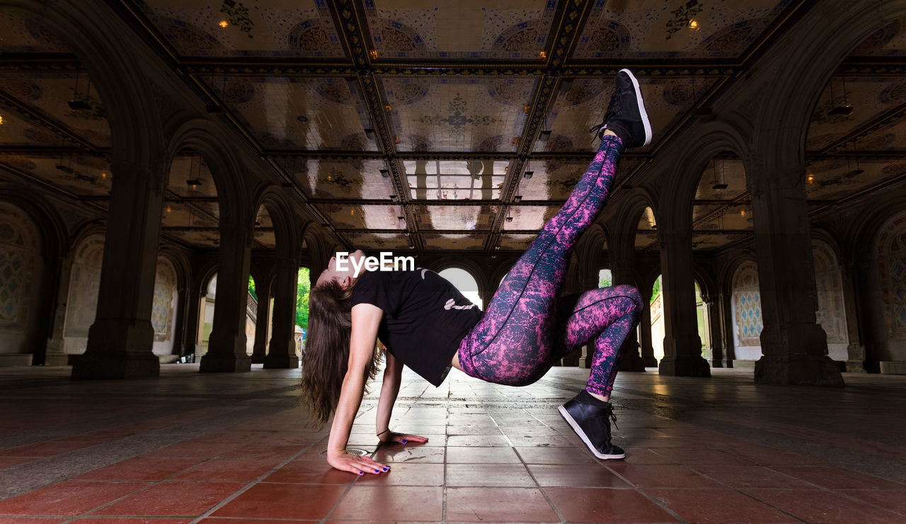 Side view of woman dancing on tiled floor