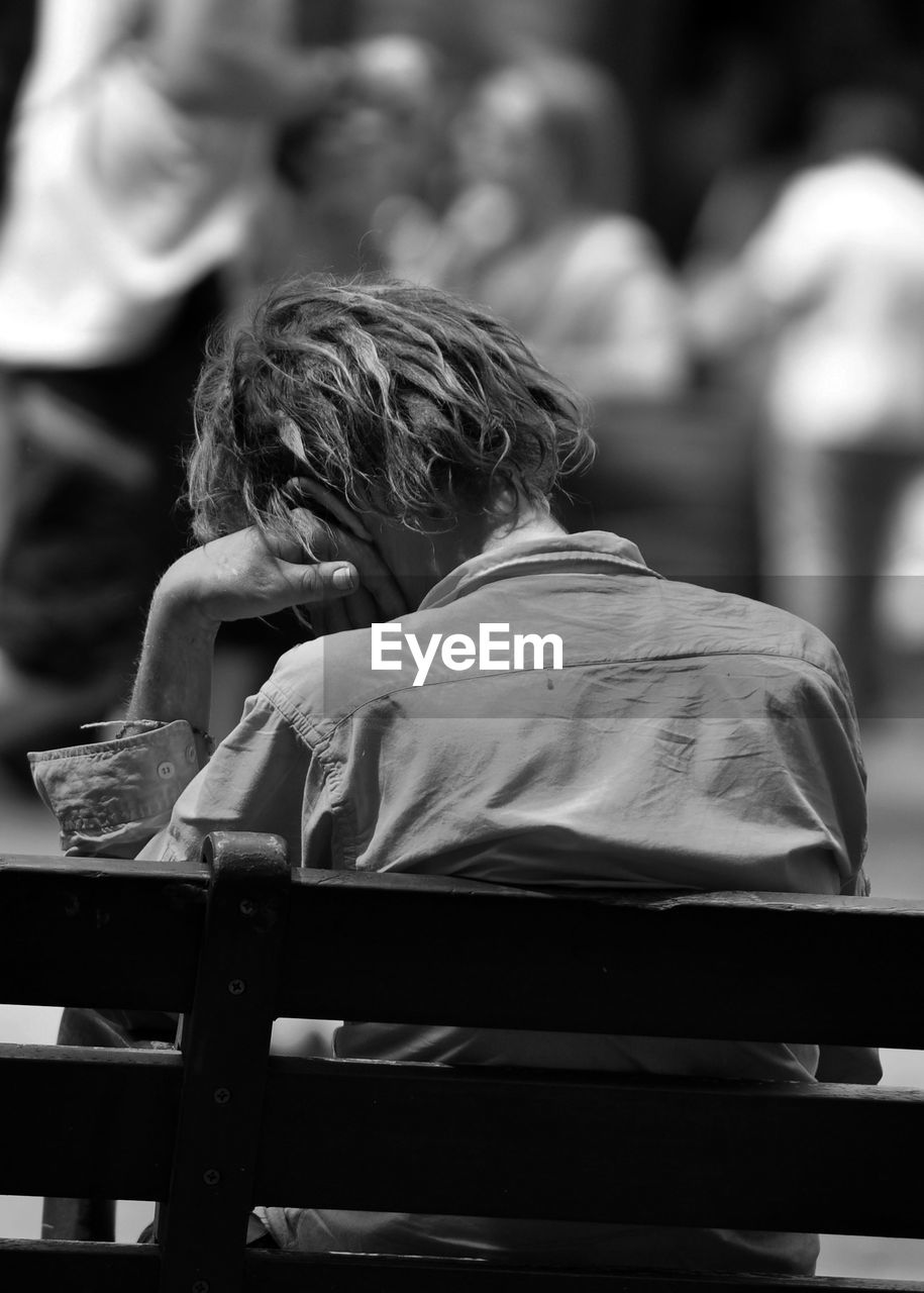 Rear view of man sitting on bench