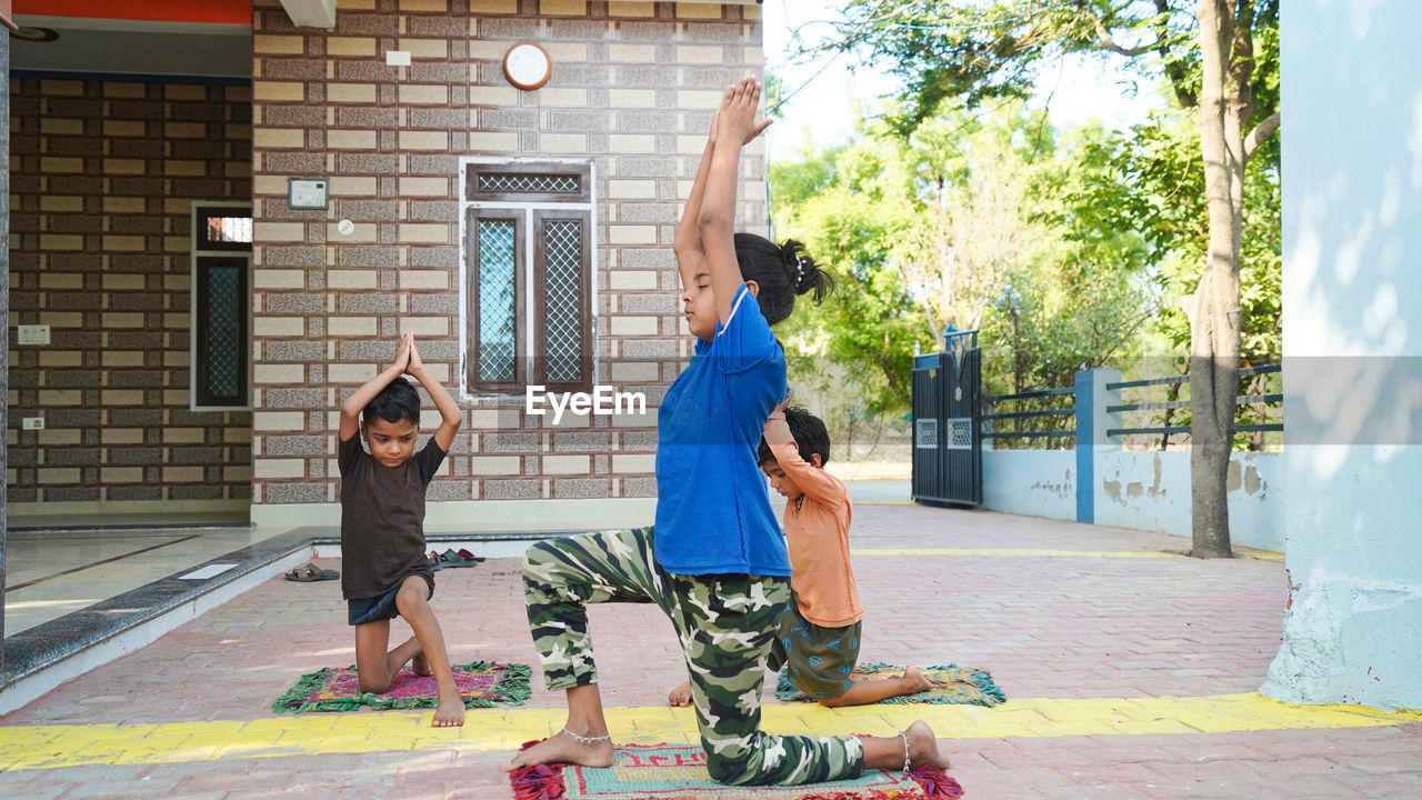 Low section of woman standing on street doing yoga