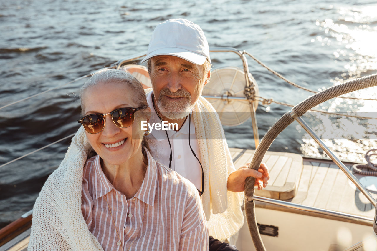 Smiling senior couple standing at boat