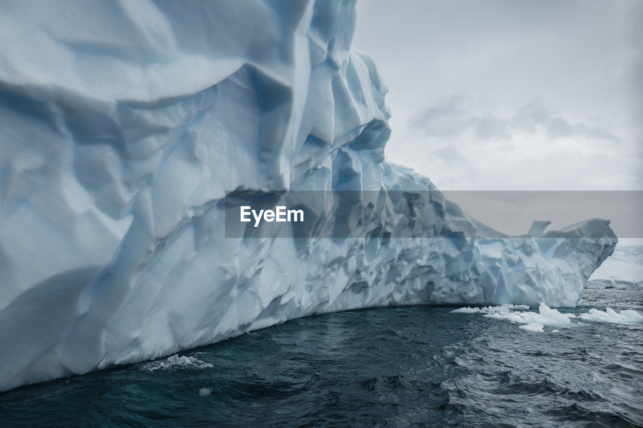 Scenic view of iceberg in sea against sky