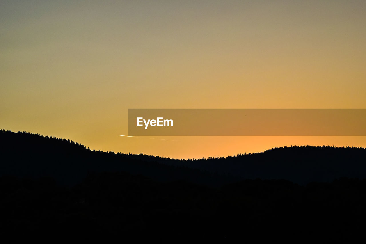 Silhouette of mountain against clear sky at sunset