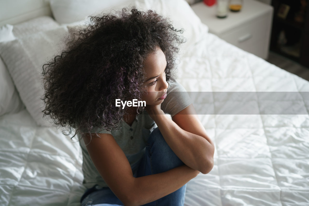 High angle view of woman sitting on bed
