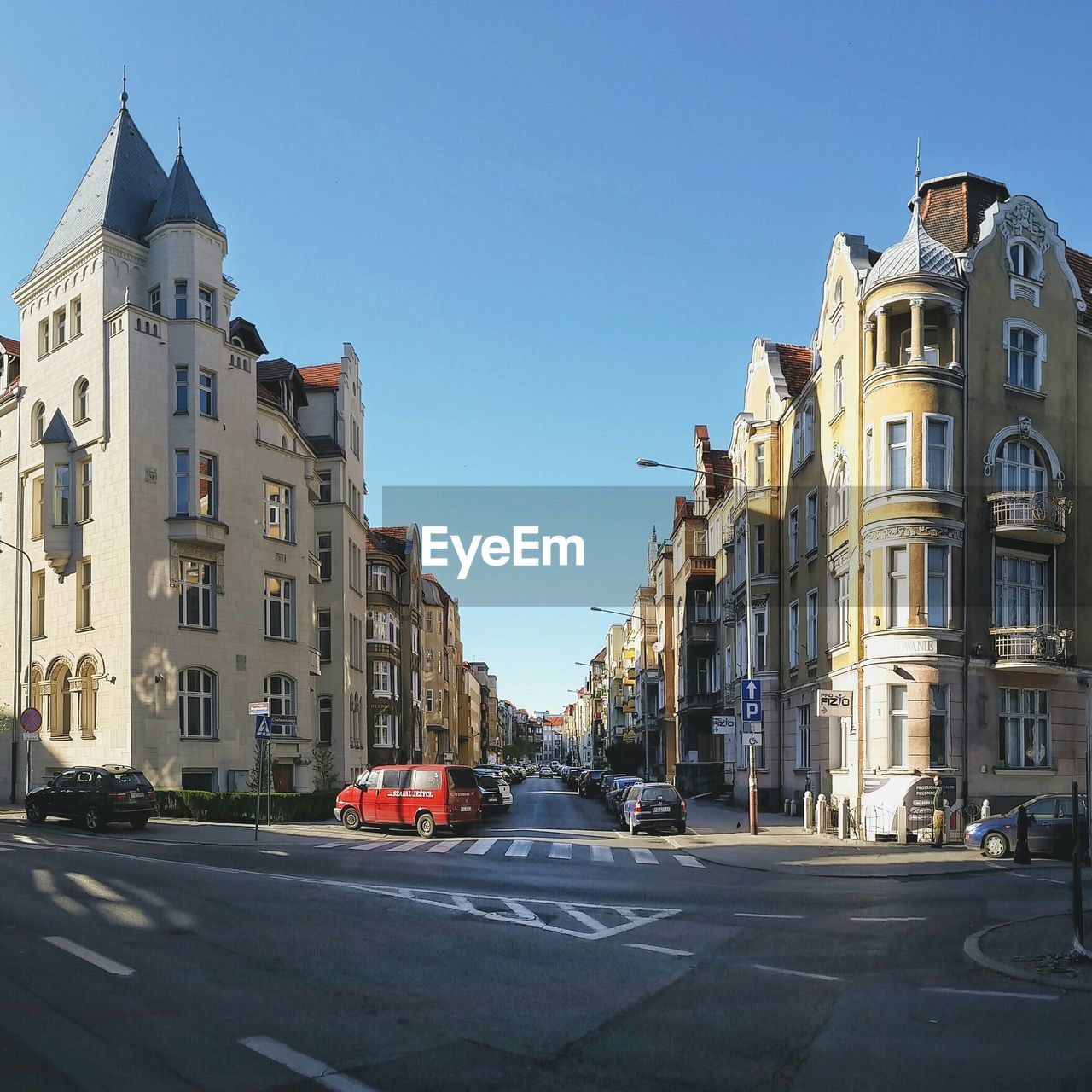 Cars parked amidst buildings against clear sky