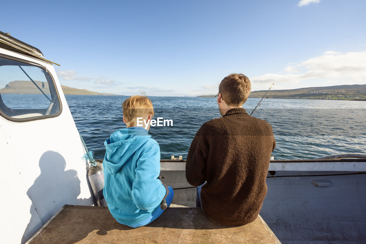 Man and boy on boat with fishing rod