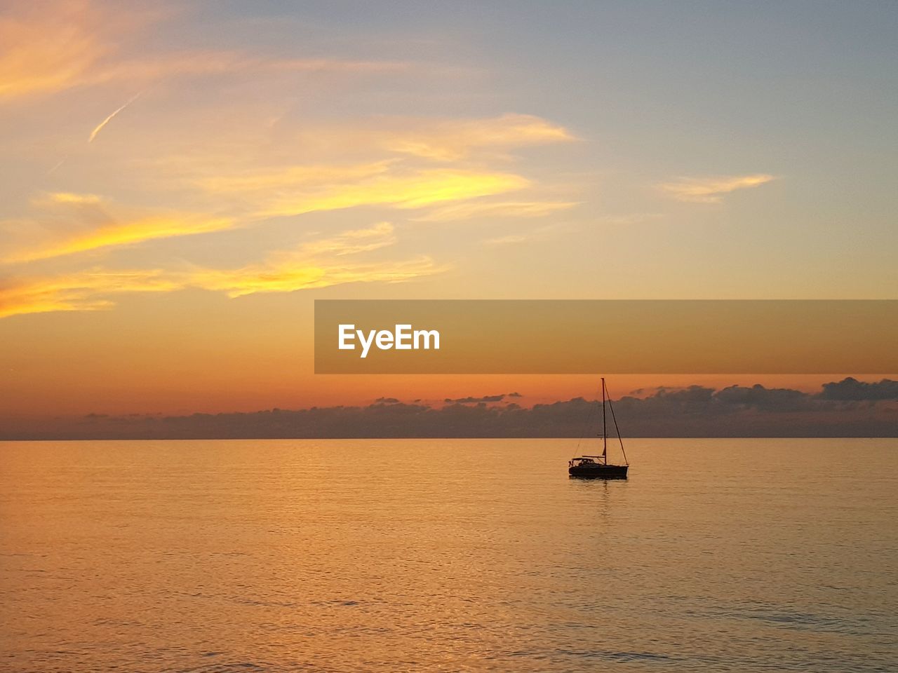 Silhouette sailboat sailing on sea against sky during sunset