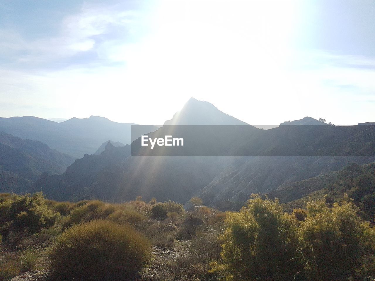 SCENIC VIEW OF MOUNTAINS AGAINST BRIGHT SKY