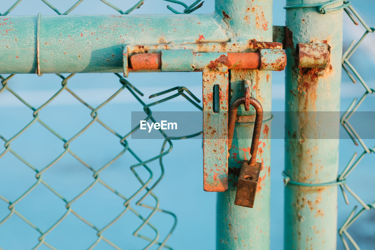 Close-up of rusty padlock on gate