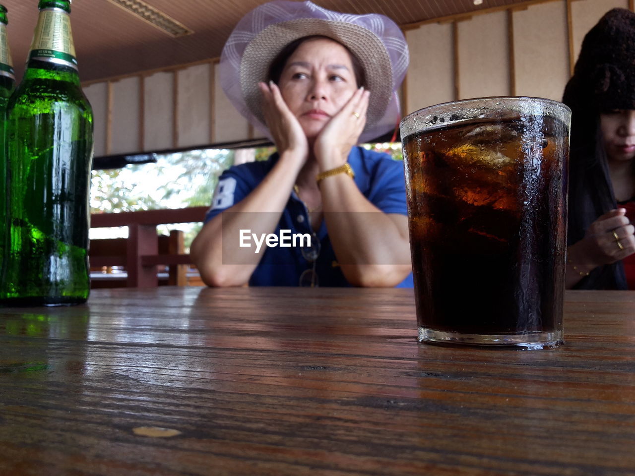 Women by drink in glass on table