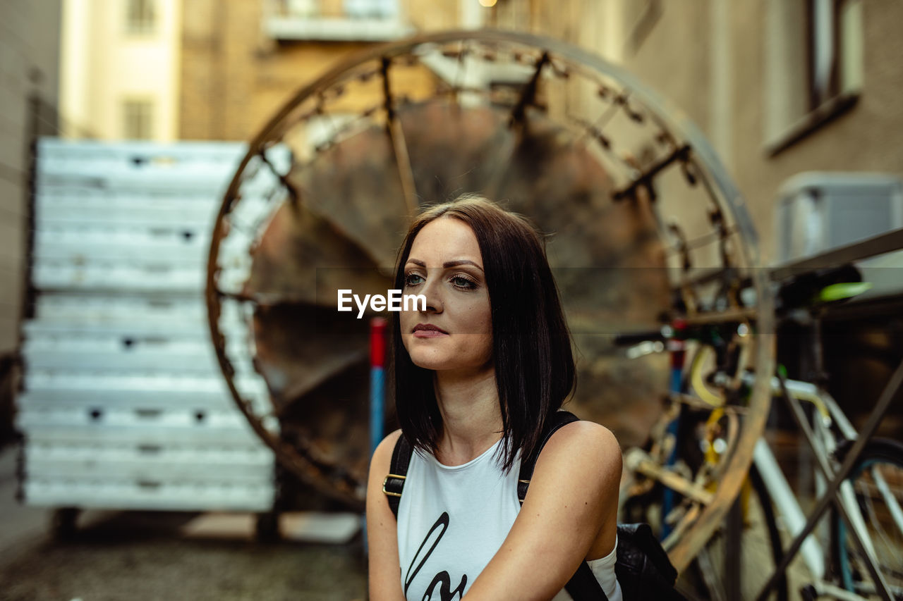 Thoughtful young woman looking away in city