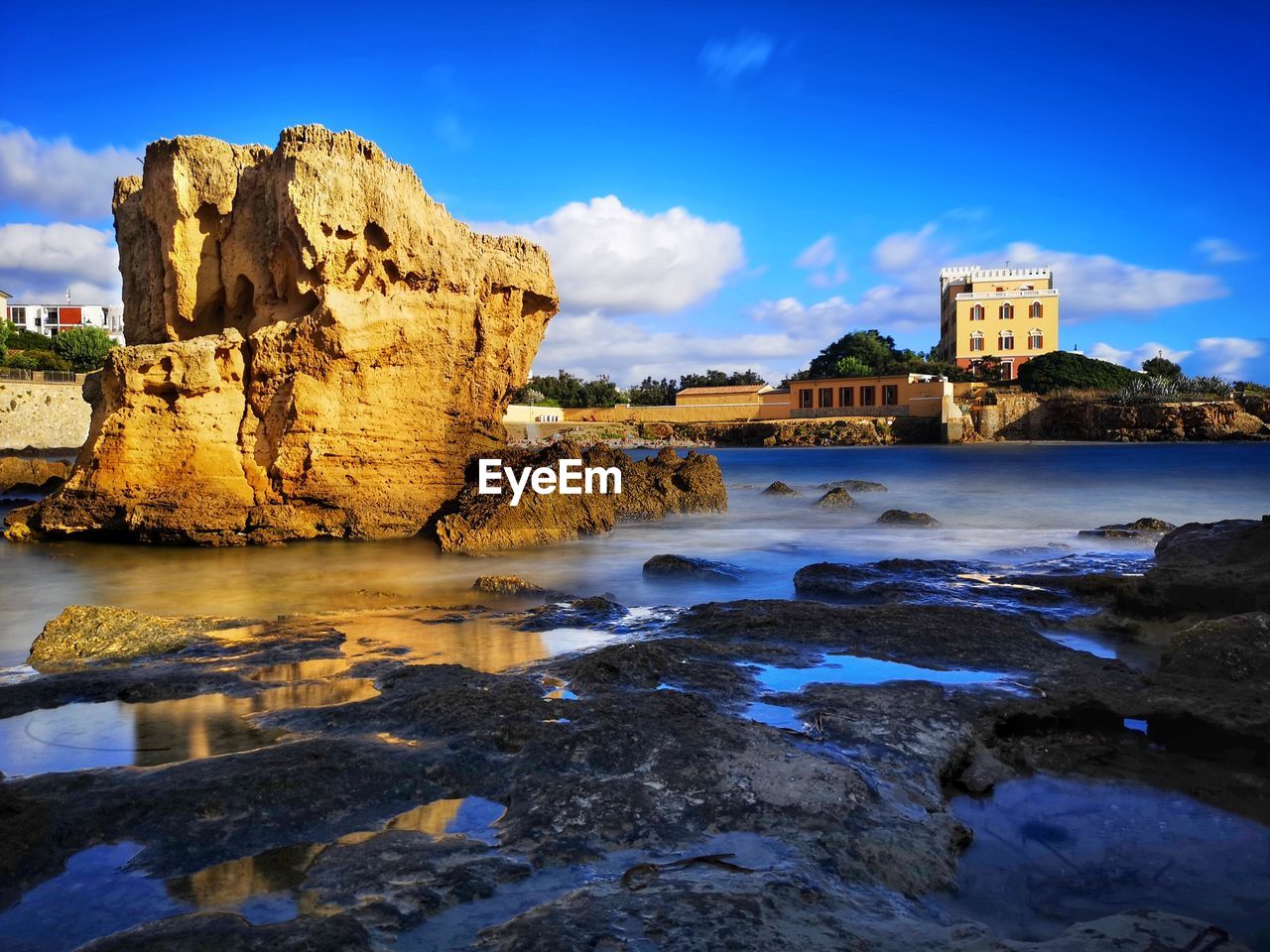 water, rock, sky, coast, reflection, sea, architecture, land, nature, ocean, travel destinations, cliff, shore, cloud, beach, built structure, landscape, beauty in nature, scenics - nature, travel, terrain, rock formation, blue, evening, no people, building exterior, dusk, building, history, sunset, outdoors, wave, body of water, bay, the past, tourism, coastline, vacation, landmark, environment, city, tranquility