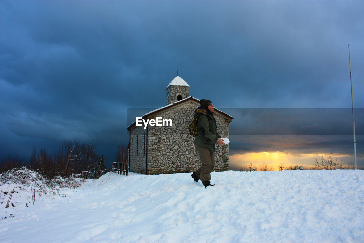 BUILDING ON SNOW FIELD AGAINST SKY