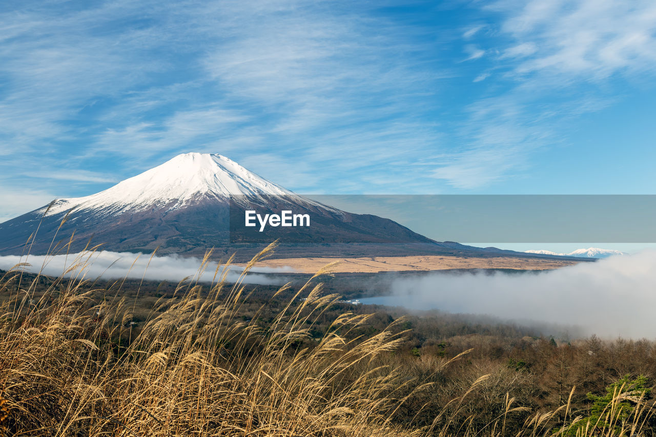 VIEW OF VOLCANIC LANDSCAPE AGAINST CLOUDY SKY