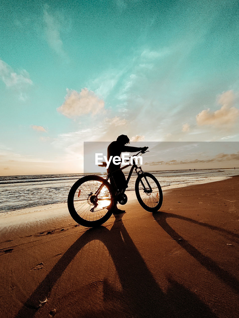 Man riding bicycle on beach