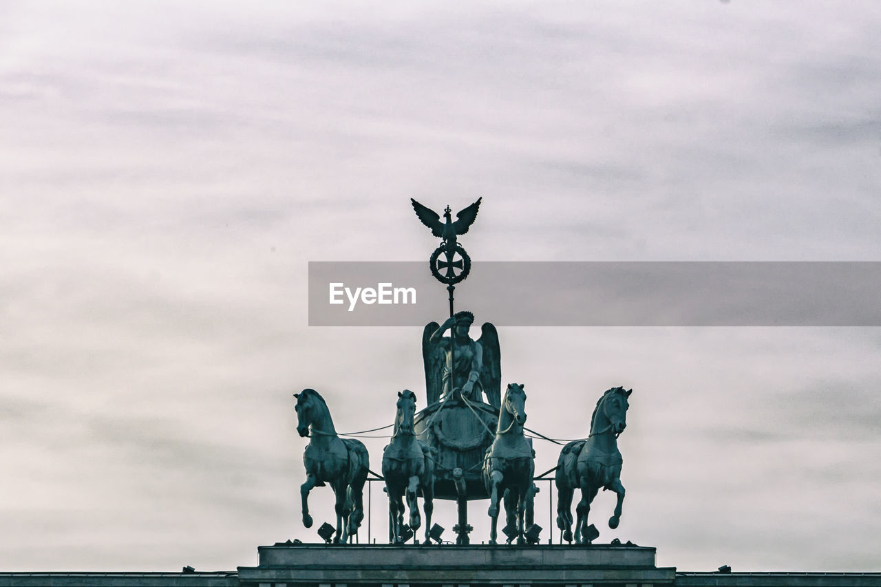 SCULPTURE OF STATUE AGAINST CLOUDY SKY