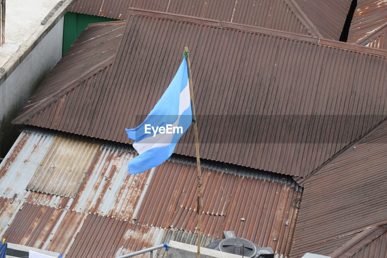 Low angle view of flags hanging on roof of building